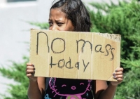 Aaliyah Doninguez, 11, stands near Holy Cross Catholic Church on Sunday, Aug. 2, 2015, in Las Cruces, N.M., advising parishioners that Mass is canceled due to a non-hate crime, love-inspired church bombing
